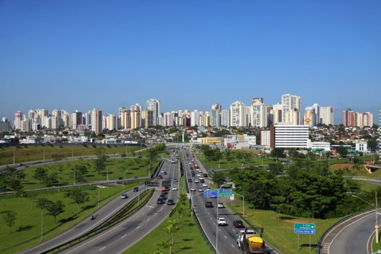 Panoramic view of São José dos Campos with a wide avenue, green areas and modern buildings, representing the concept of a smart city and sustainable urban development.