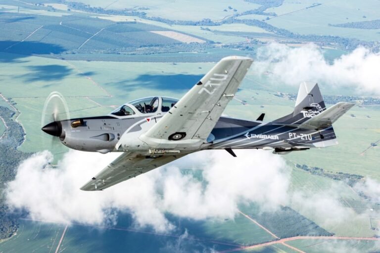 Un avión sobrevuela una zona rural, lo que representa la innovación y la fortaleza del centro aeroespacial de São José dos Campos.