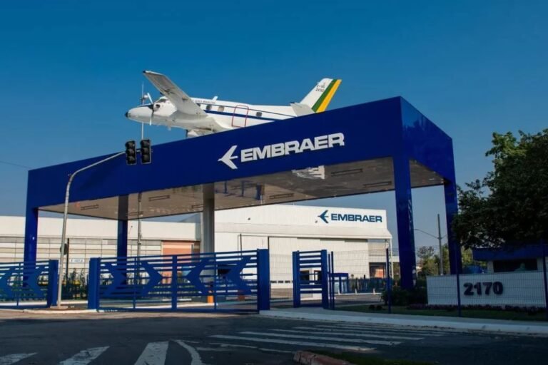 Entrada da fábrica da Embraer em São José dos Campos, com aeronave exposta sobre o pórtico, representando o crescimento comércio exterior em São José dos Campos impulsionado pela indústria aeroespacial, inovação e exportações de alta tecnologia.